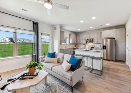 a living room and kitchen with a couch and a table