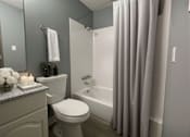 Thumbnail 8 of 8 - A white toilet sits next to a bathtub in a bathroom.