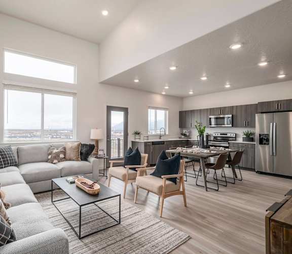 A modern living room with a grey sofa and a glass coffee table.