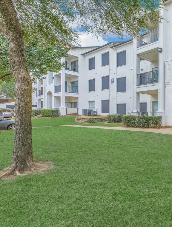 a courtyard with a playground and yellow chairs in front of an apartment building