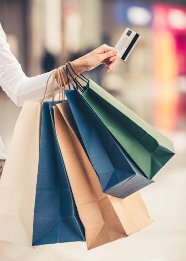 A person holding a credit card and shopping bags at The Laurent at Laurel Apartments, Edmonton, AB, T6T 2T5