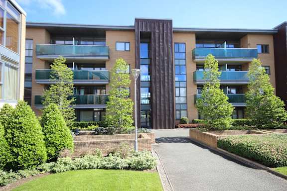 a view of a building with a pathway and trees