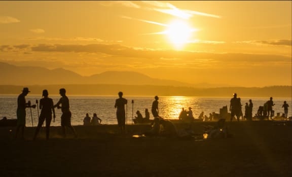 people watching the sunset on the beach  at The Hemlock, Washington, 98103