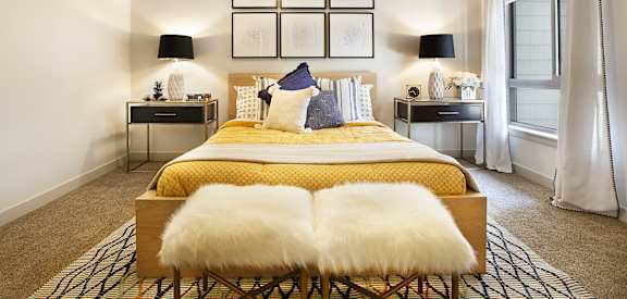 A bedroom with a bed, two lamps, and a ceiling fan. at Liberty Blvd Apartments - Saltlake City, UT Apartments, Saltlake City, Utah