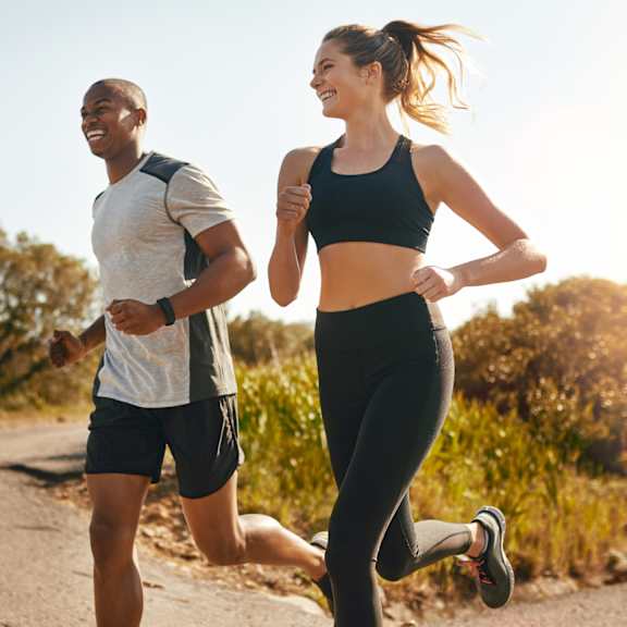 A man and a woman are jogging outdoors.