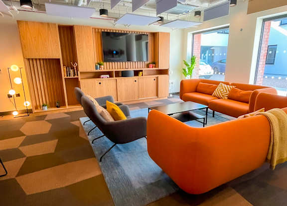 a large living room with orange couches and a television