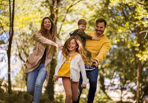 a family walking through the woods with a child