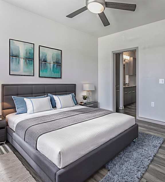 A bedroom with a large bed and a ceiling fan.