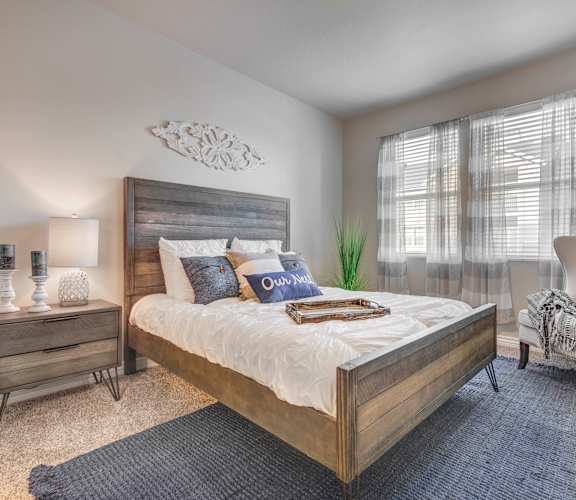 a bedroom with a large bed and two windows