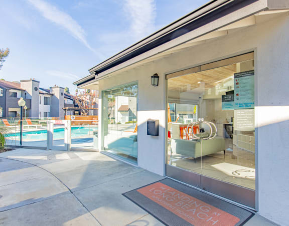 the entrance to a building with glass doors and a swimming pool