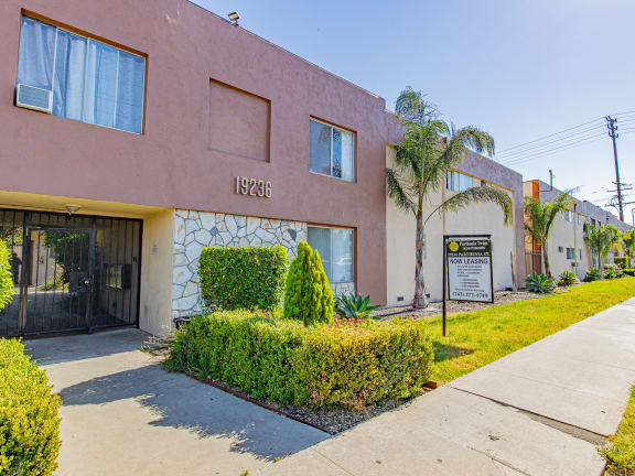 a pink building with a sign on it and a sidewalk