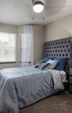 A bedroom with a four poster bed and a painting on the wall.