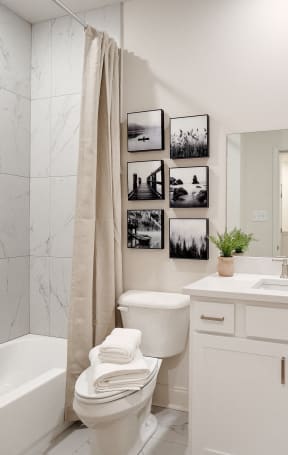 a white bathroom with a shower toilet and sink