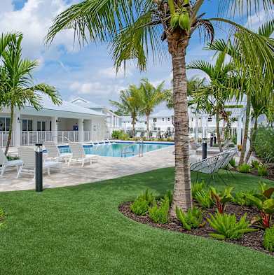 the pool is surrounded by palm trees and white chairs