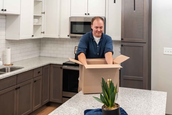 a man opening a box in a kitchen