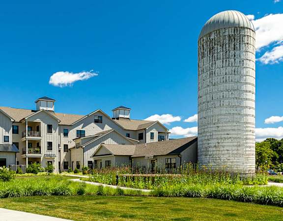 A large white building with a tall silo in front of it.