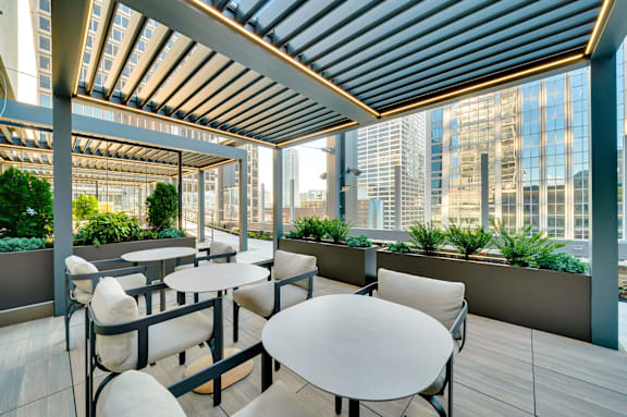 A patio with tables and chairs overlooking a cityscape. at 17 Market West, Philadelphia, PA 19103