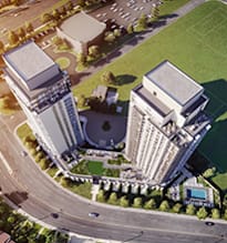 A large building complex with a green area in front.