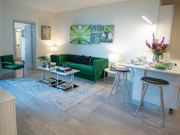A living room with a green couch and a white table at 42 Hundred On The Lake, St Francis, WI