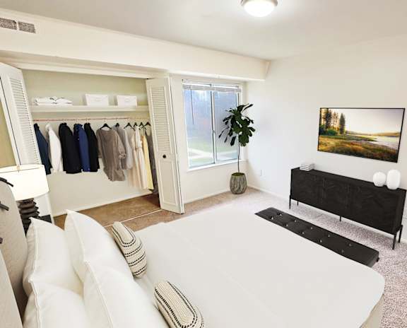 A white living room with a couch, a black bench, and a clothing rack.