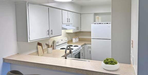 A modern kitchen with white appliances and cabinets.