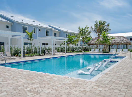 a large swimming pool in front of a hotel