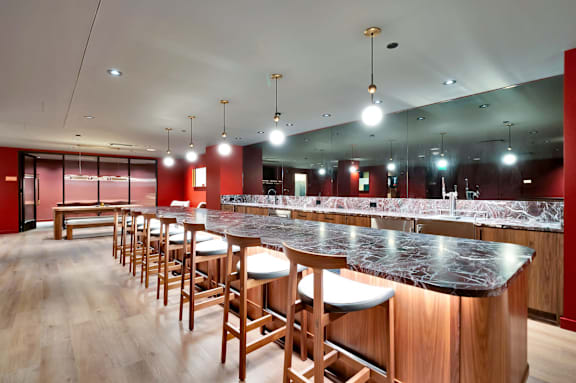 A long bar with wooden chairs and a marble counter. at 17 Market West, Philadelphia, PA 19103