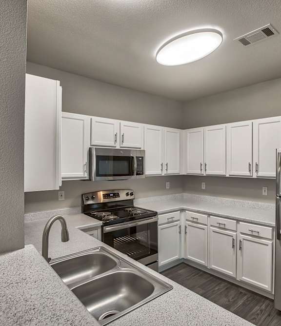 A kitchen with white cabinets and stainless steel appliances.
