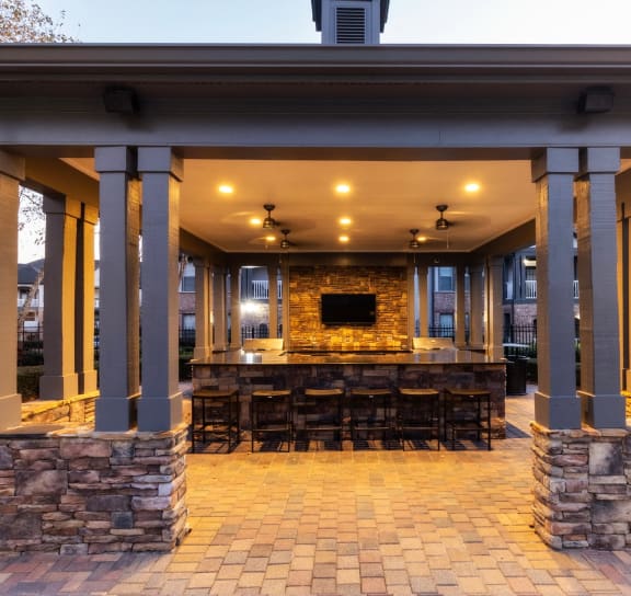 a covered patio with a bar and a fireplace