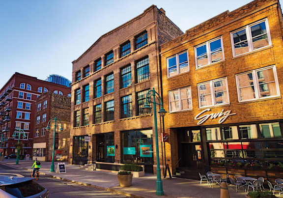 A street view of a city with a building that has a sign that says "Swig".