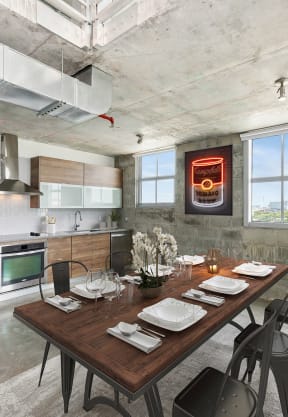 a kitchen and dining area with a wooden table and chairs and a stainless steel refrigerator and stove