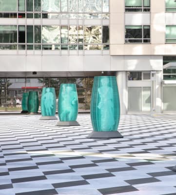 a row of turquoise coloured sculptures in front of a building