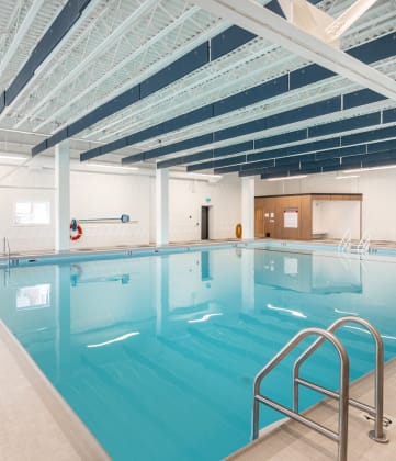 a large indoor swimming pool with white walls and ceilings