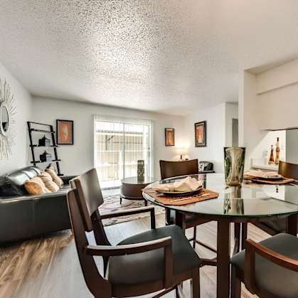 A dining room with a glass table and chairs.