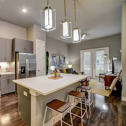 A modern kitchen with a white island and stainless steel appliances.