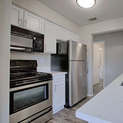 A kitchen with a stainless steel refrigerator and oven.