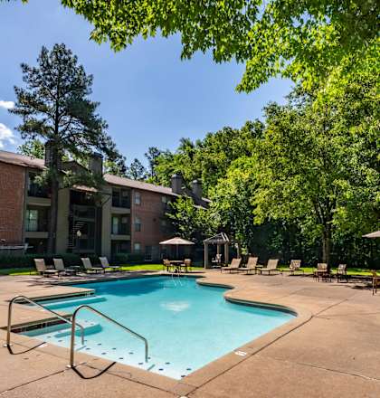 our apartments offer a swimming pool with chairs and trees at The Summit Apartments, Memphis, Tennessee