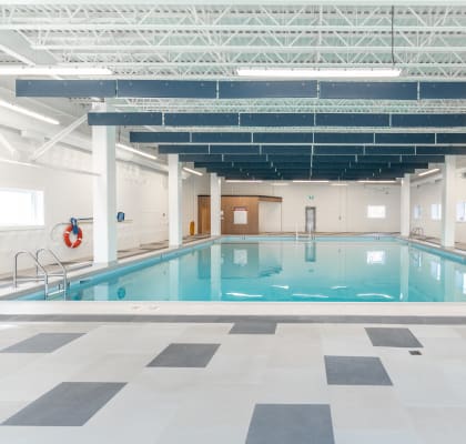 a large indoor swimming pool with white walls and ceilings and a checkered floor