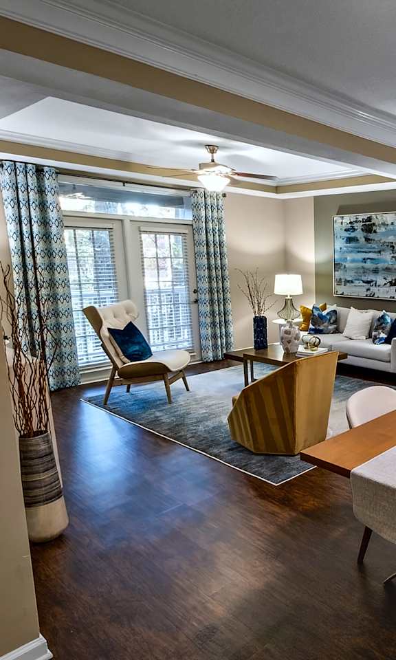 A well-lit, spacious living room with a dining table and chairs.