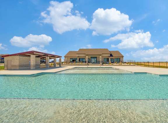 A large swimming pool in front of a house.