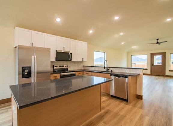 A kitchen with a black counter top and wooden cabinets.