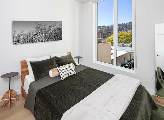 a bedroom with a bed and a large window at The Weidler in Portland, OR 97209