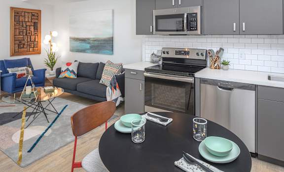 A modern kitchen with a dining table set for two.