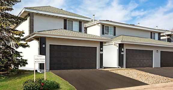 Summit Townhomes in Burnsville, MN photo of a house with a garage door and a sign in front of it