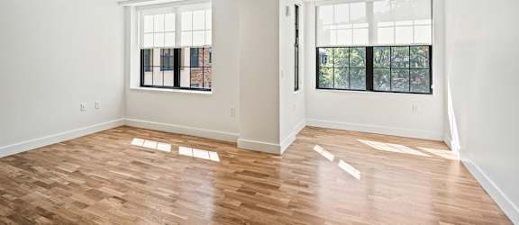 an empty living room with white walls and wood floors