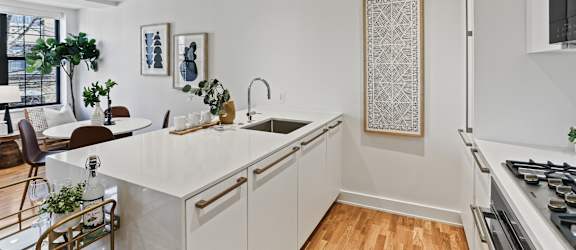 A modern kitchen with white cabinets and a large island.