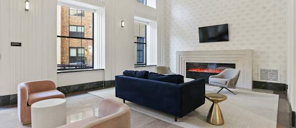 A living room with a blue couch and a fireplace.
