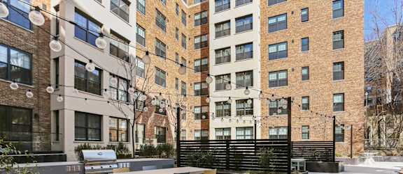 A patio with a table and chairs is surrounded by buildings.