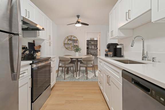 A modern kitchen with white cabinets and stainless steel appliances.