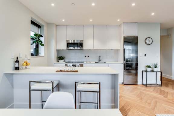 Custom kitchen with quartz countertops, hardwood floors and Bosch appliances and an island